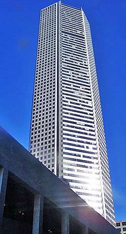 Tall, steel, five-sided tower, with strong vertical lines broken by rows of  horizontal bands on two sides.