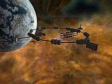 A brown murky cloud is set against a black void. In front of the cloud at the top left is a grey sphere, pockmarked with craters. A metal structure, consisting of cylinders interconnected in the shape of a ring, floats in the foreground.