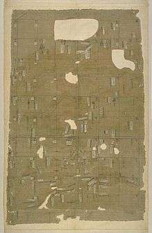 Cloth divided into squares with labels. Part of the cloth is missing leaving holes in the fabric.