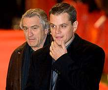 Photo of Damon and De Niro, each wearing a tuxedo jacket and a dark blue shirt.