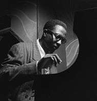 Black and white photograph of a man playing piano