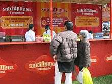 Photograph of two persons ordering food at a kiosk